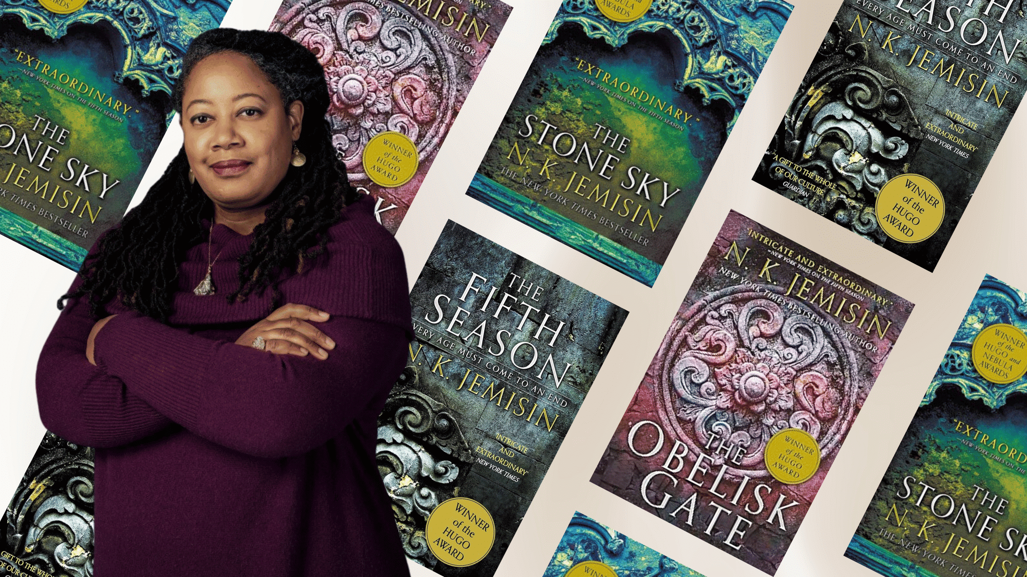 Author N.K. Jemisin wearing a purple sweater stands around her award-winning fantasy novels from the The Broken Earth Trilogy.