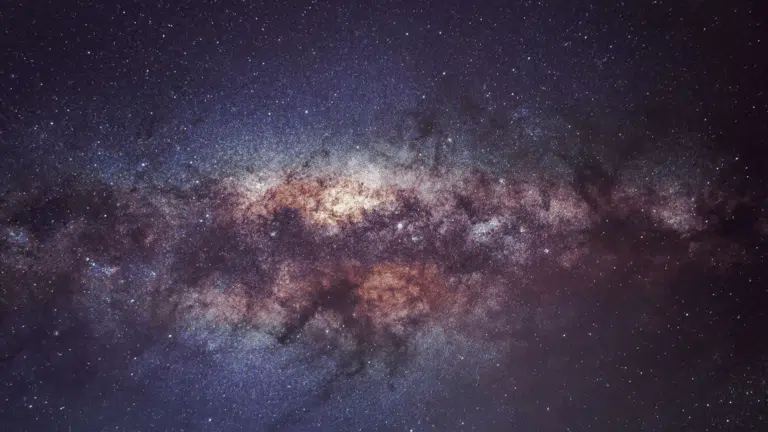 Vibrant wide-field astrophotography captures the dense, dusty core of the Milky Way galaxy against a dark, star-filled night sky.