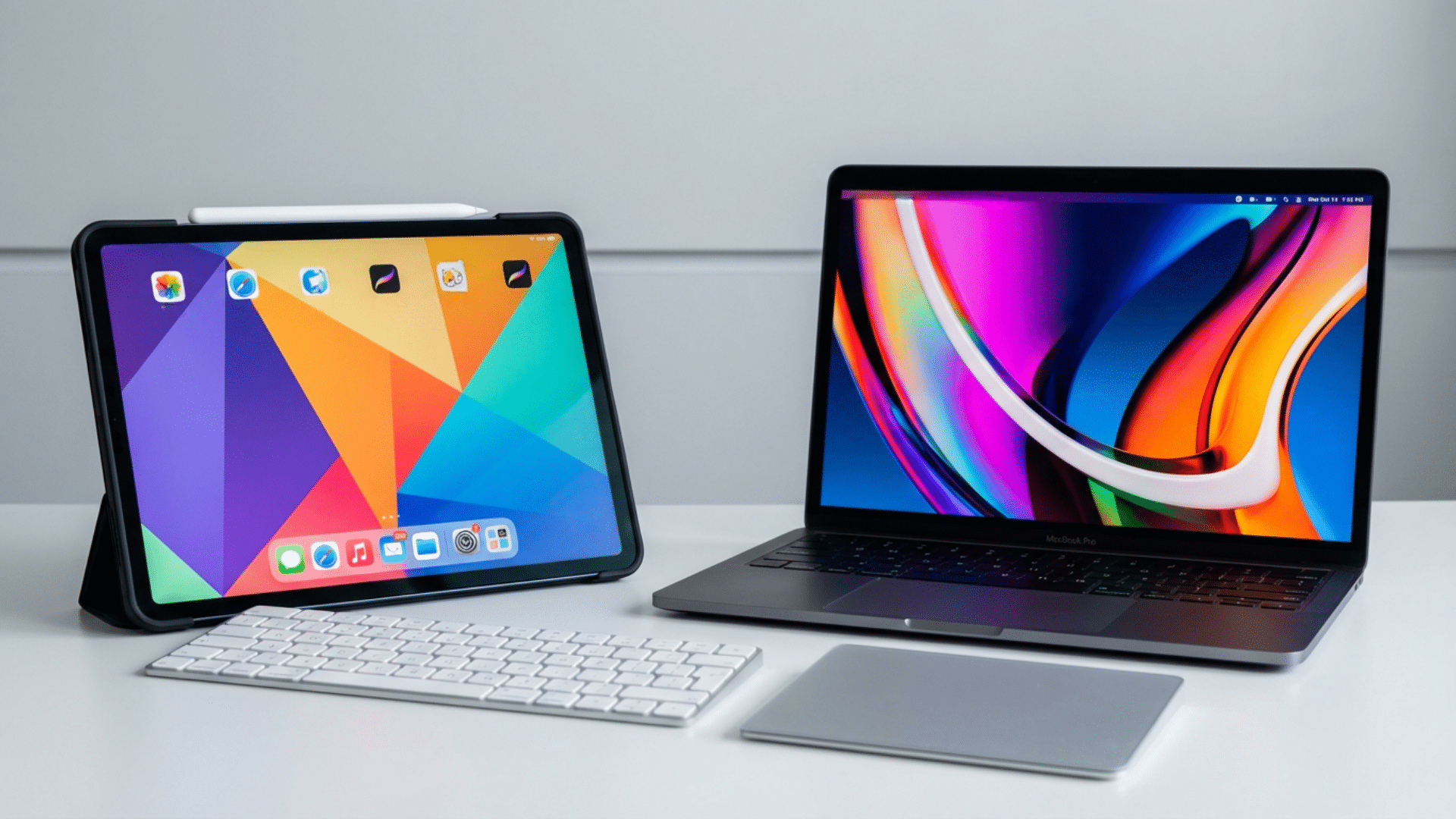 MacBook and iPad placed on a desk showing their design and everyday workspace differences