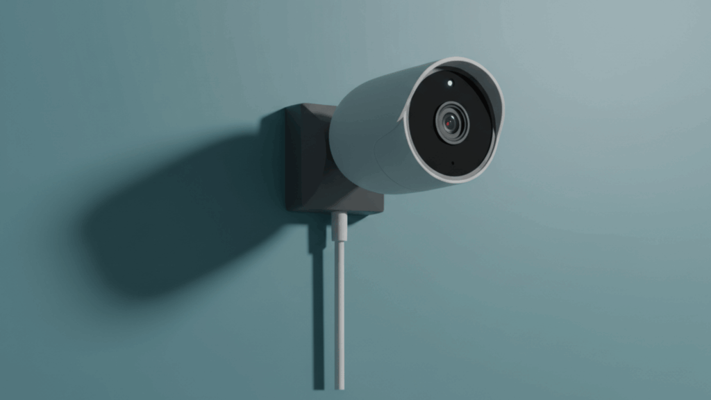 Outdoor security camera mounted on wall with power cable and wide-angle lens