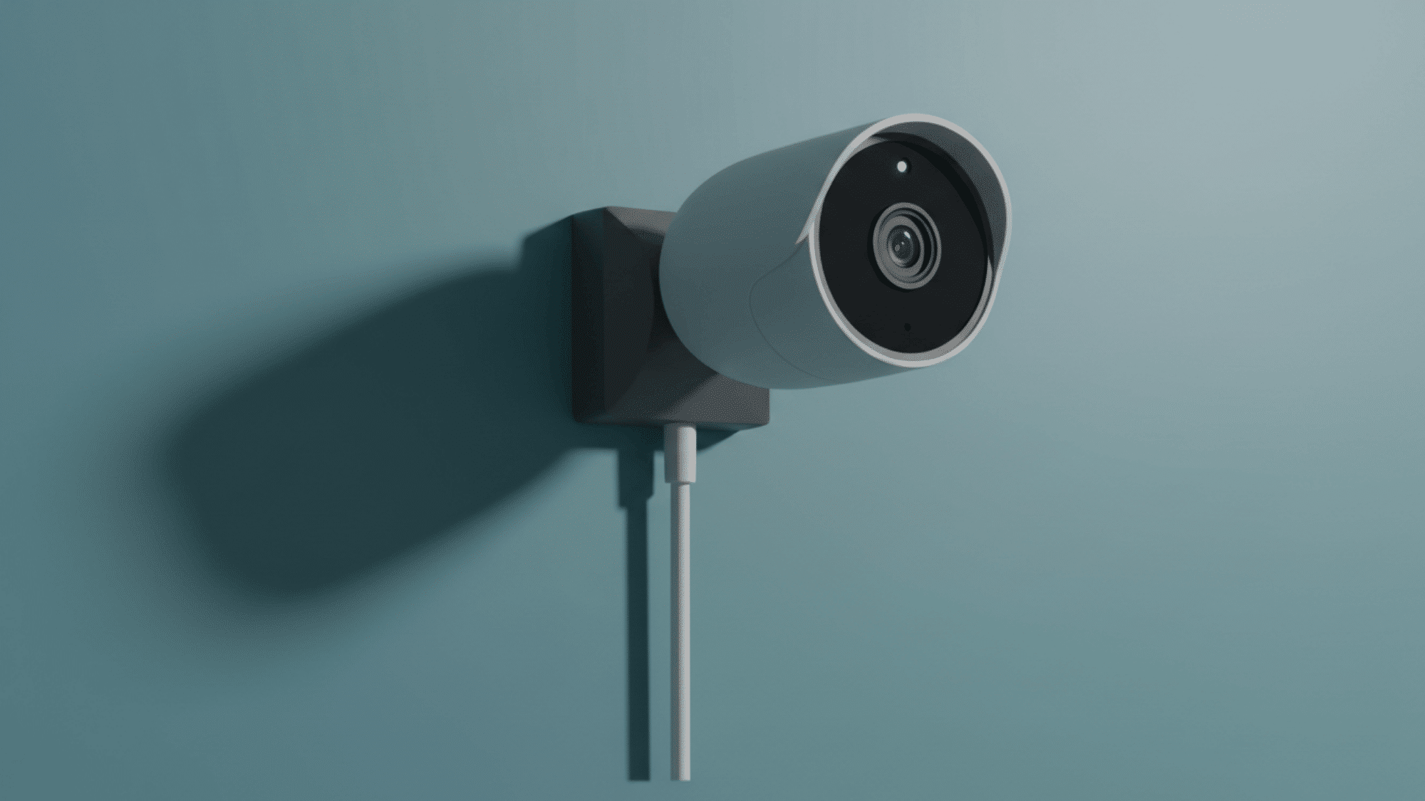 Outdoor security camera mounted on wall with power cable and wide-angle lens