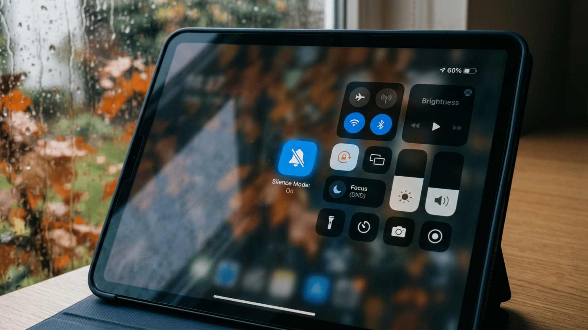 iPad Control Center with bell icon highlighted showing how to enable silent mode quickly