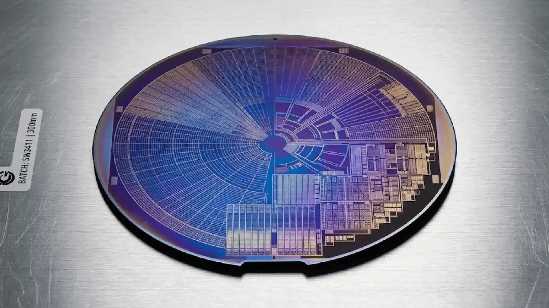 macro shot of a silicon wafer with iridescent circuit patterns on a brushed aluminum cleanroom surface