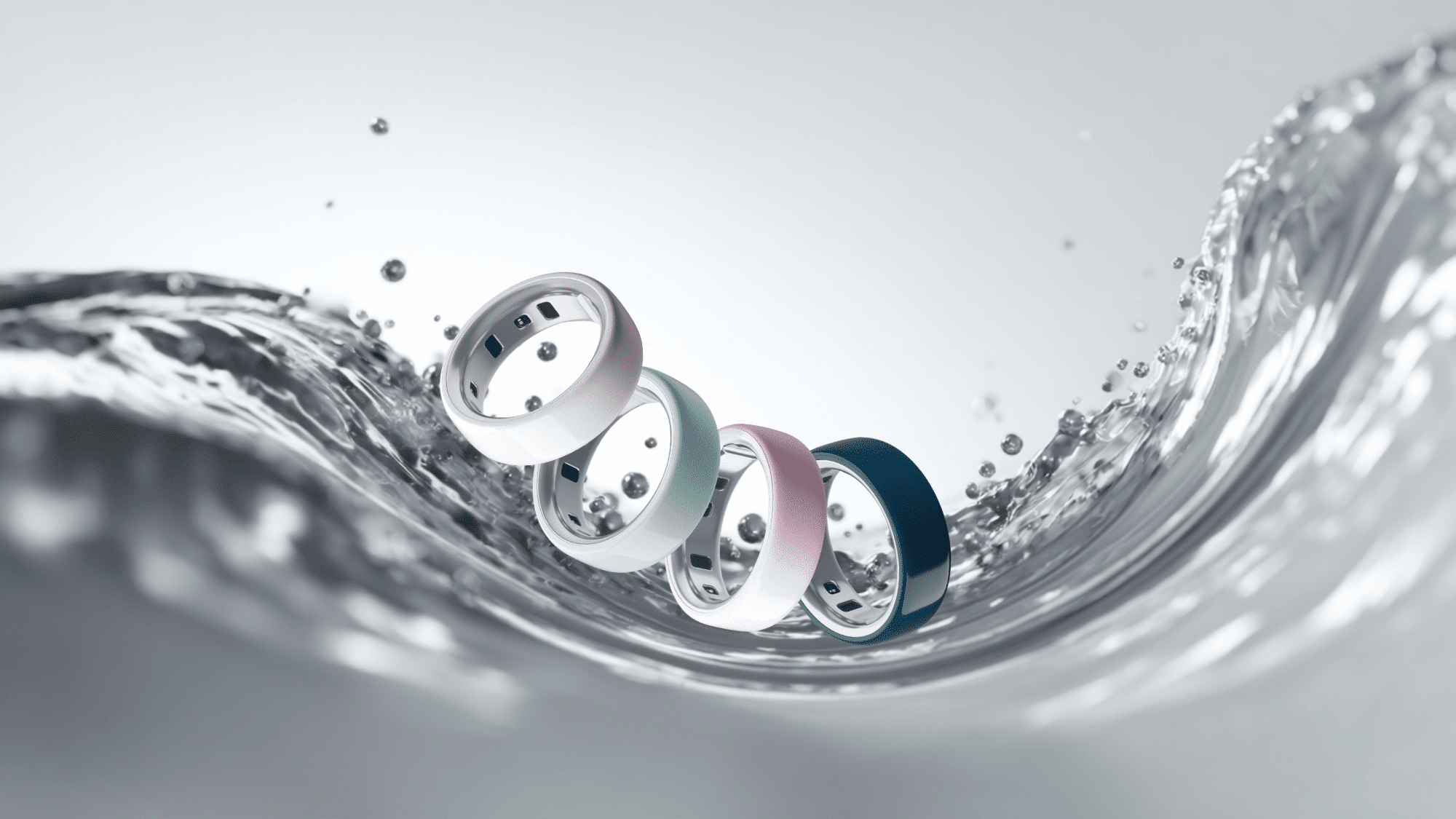 Four Oura Ring 4 smart rings in white, green, pink, and navy blue float above a curving water wave against a light background