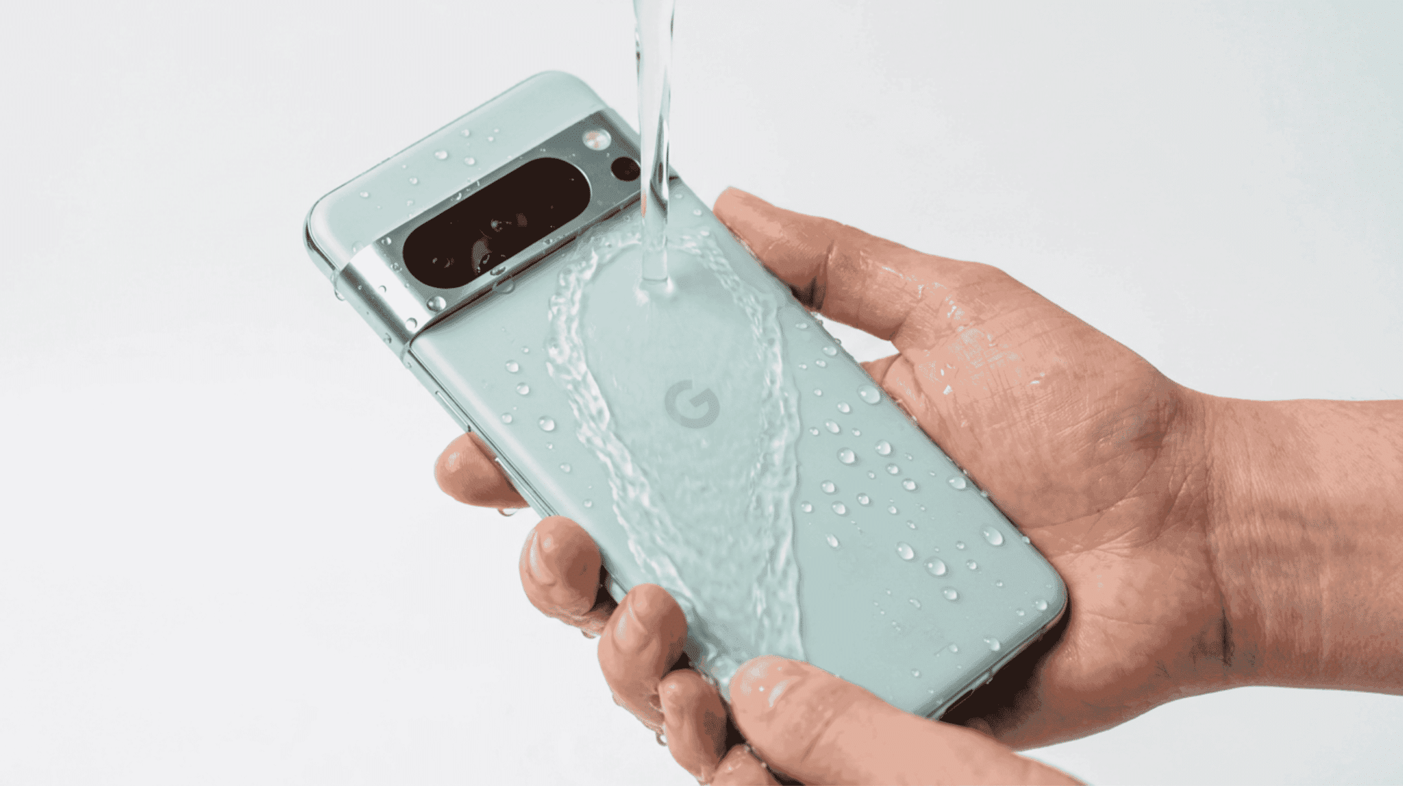 Google Pixel 8 Pro being rinsed under water demonstrating its IP68 water resistance rating
