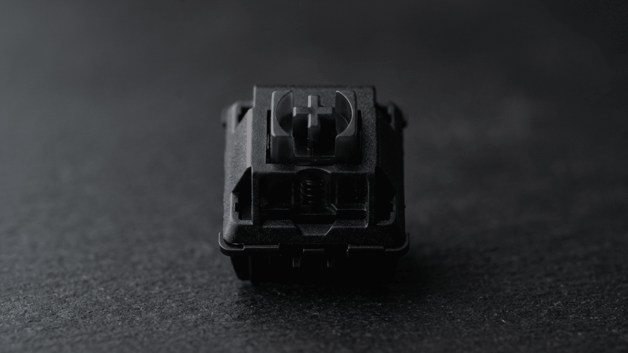 Boba U4 switch with solid black housing photographed on dark gravel surface