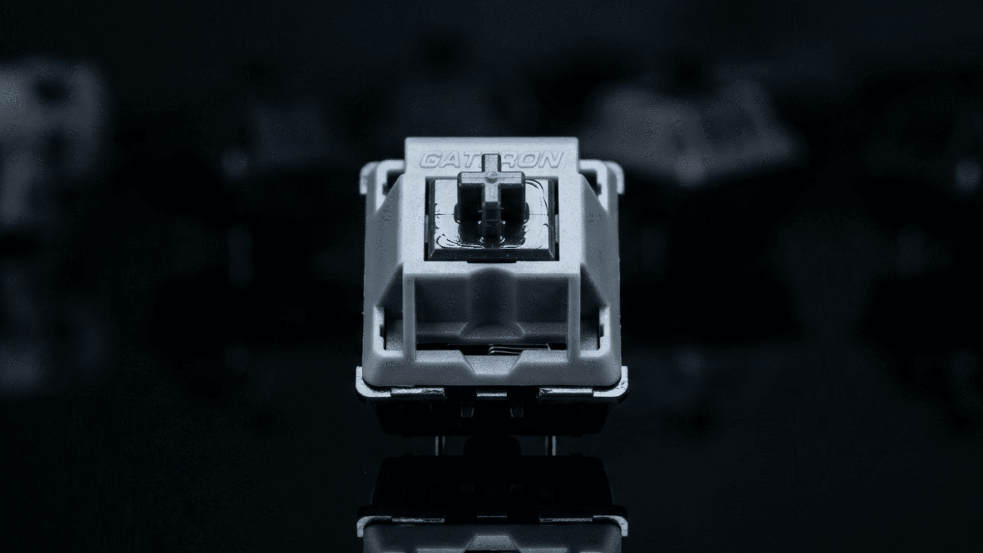 Gateron Oil King switch with gray housing and visible lubrication on dark background