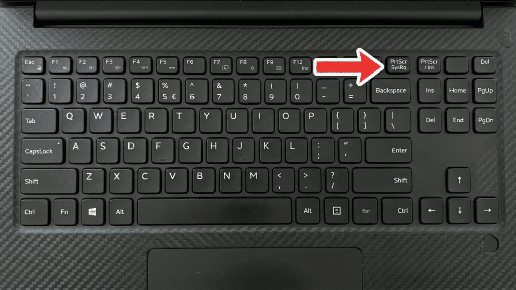 Laptop keyboard with a red arrow pointing to the PrtScr SysRq key