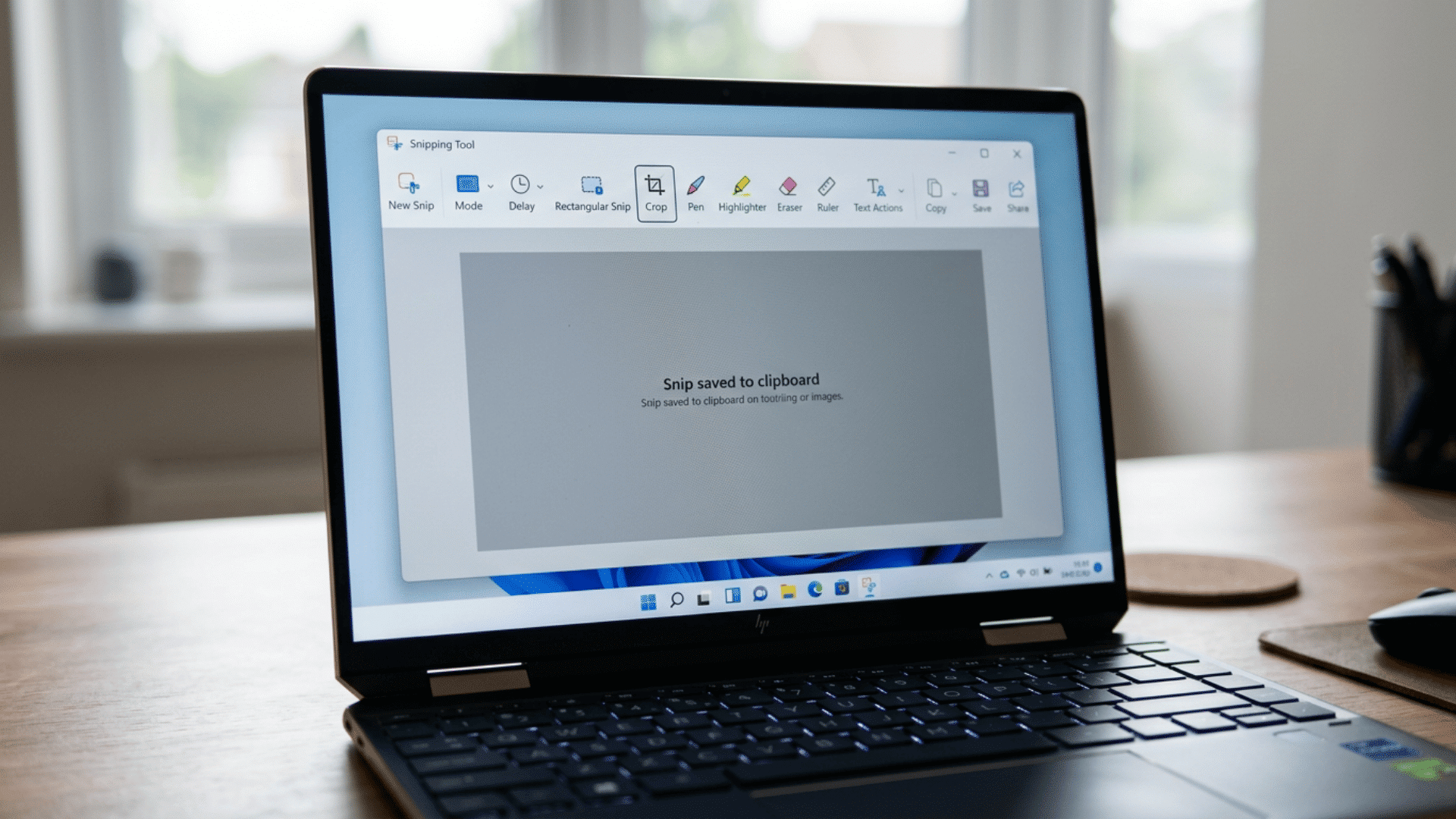 Laptop screen showing the Windows Snipping Tool with editing icons.