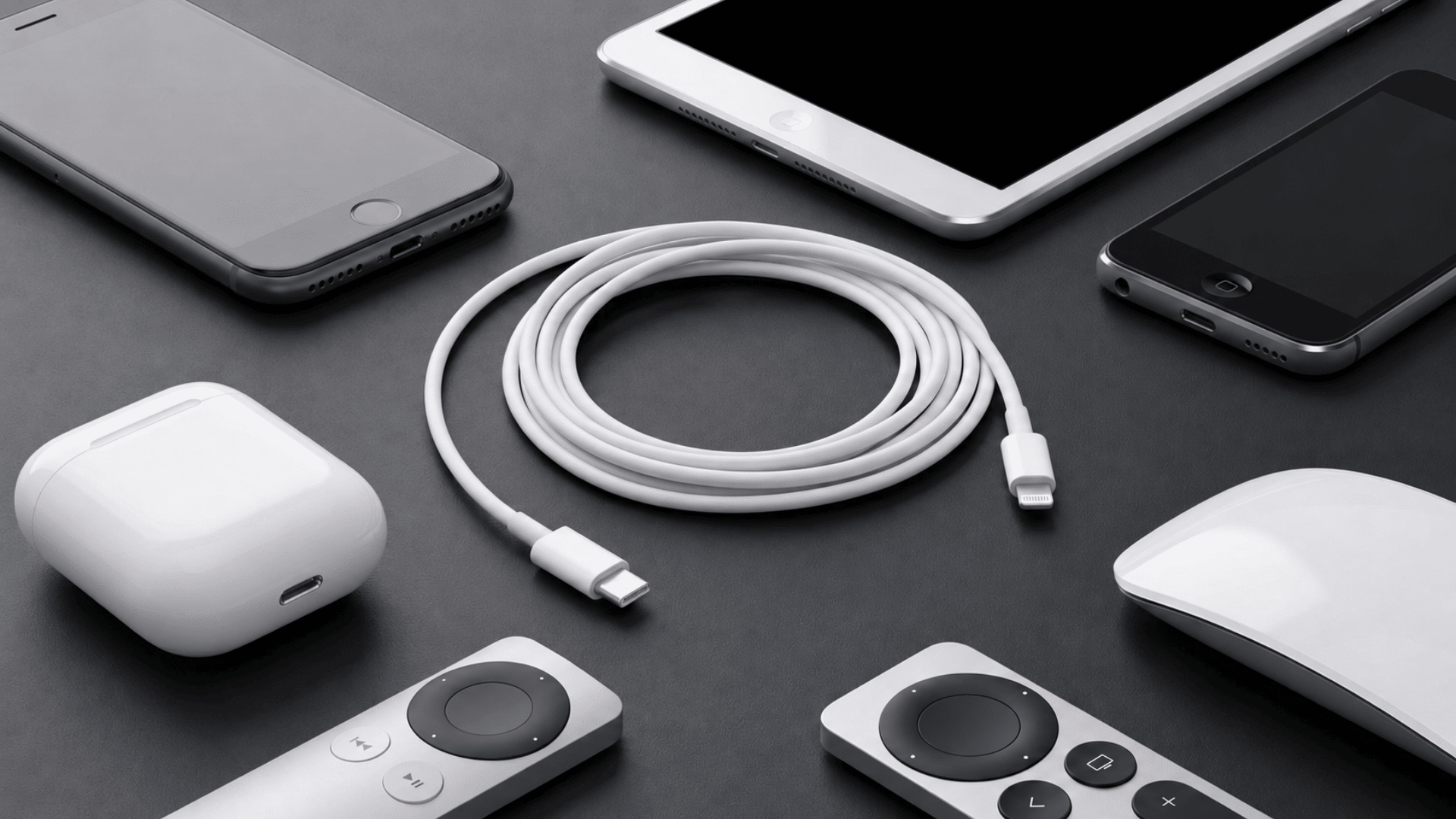 coiled white lightning cable surrounded by phones, a tablet, and accessories