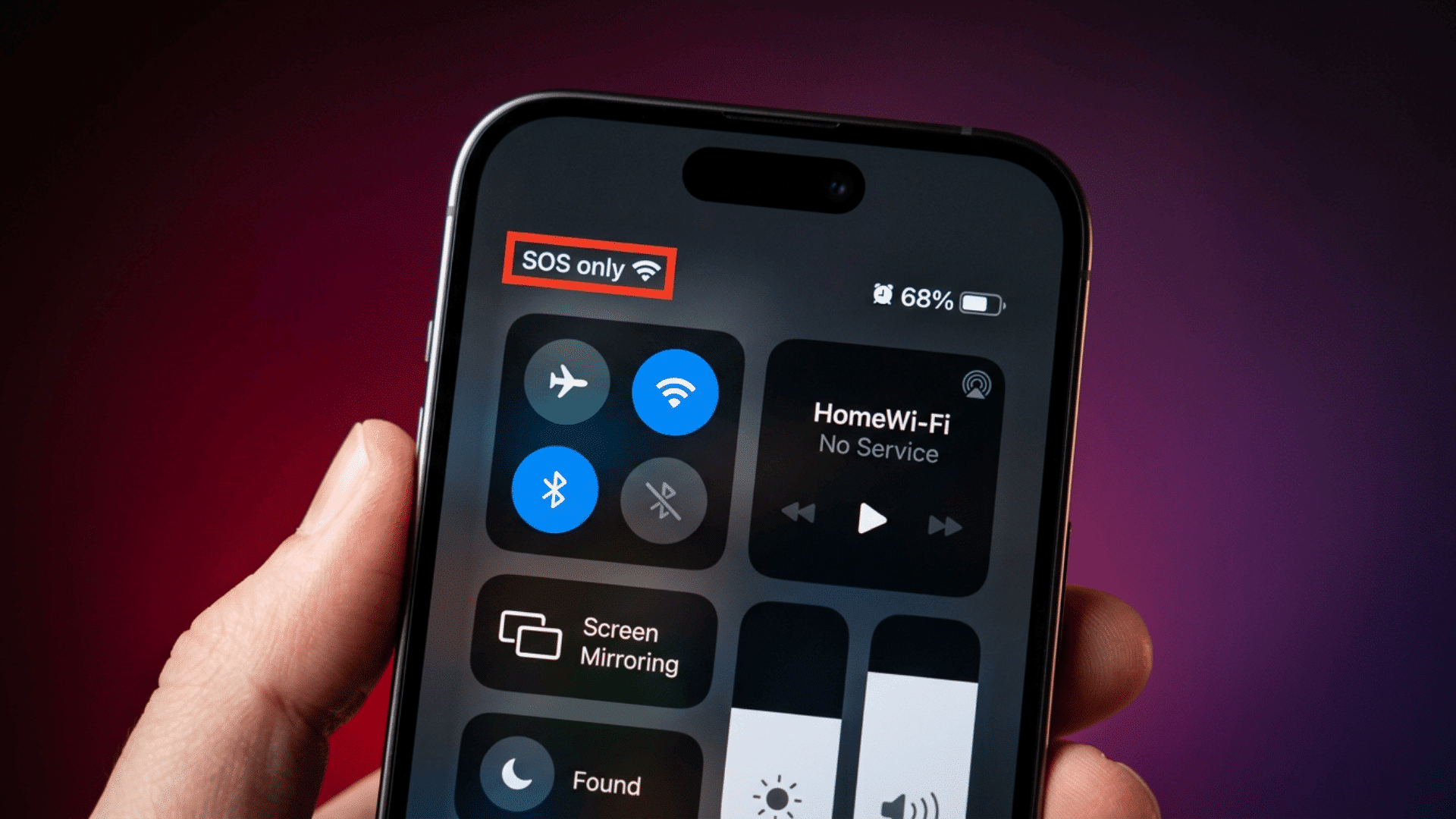 hand holding an iphone showing sos only in control center with no cellular service