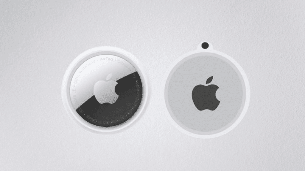 two airtags showing the front and back design with apple logo on a white surface