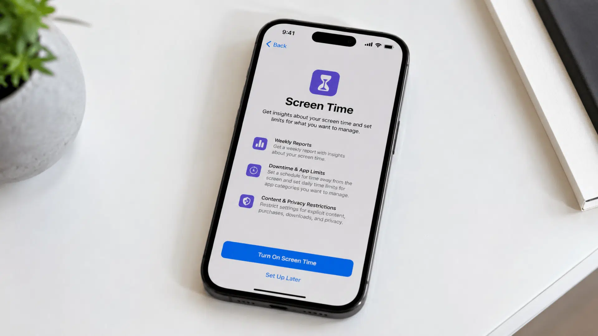 iPhone displaying the Screen Time setup page on a wooden desk