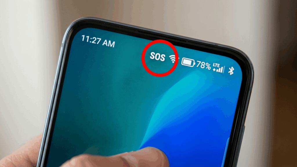 close-up of an iphone screen showing sos status circled beside wifi and battery icons