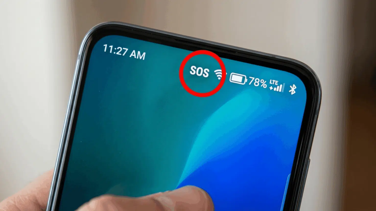 close-up of an iphone screen showing sos status circled beside wifi and battery icons