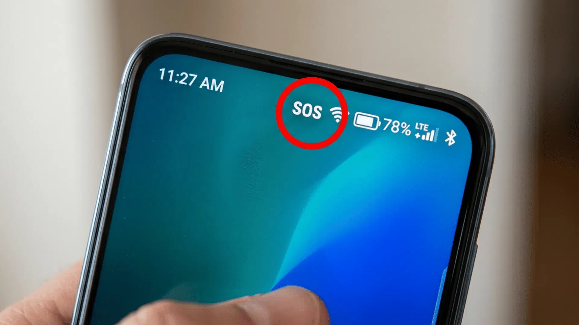 close-up of an iphone screen showing sos status circled beside wifi and battery icons