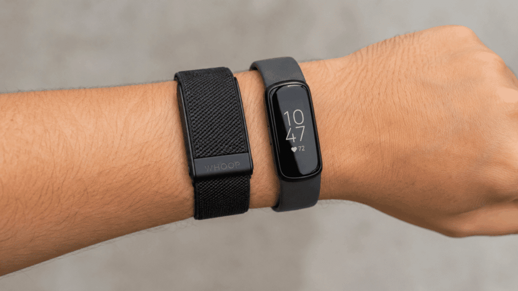 wrist wearing WHOOP and Fitbit fitness trackers side by side