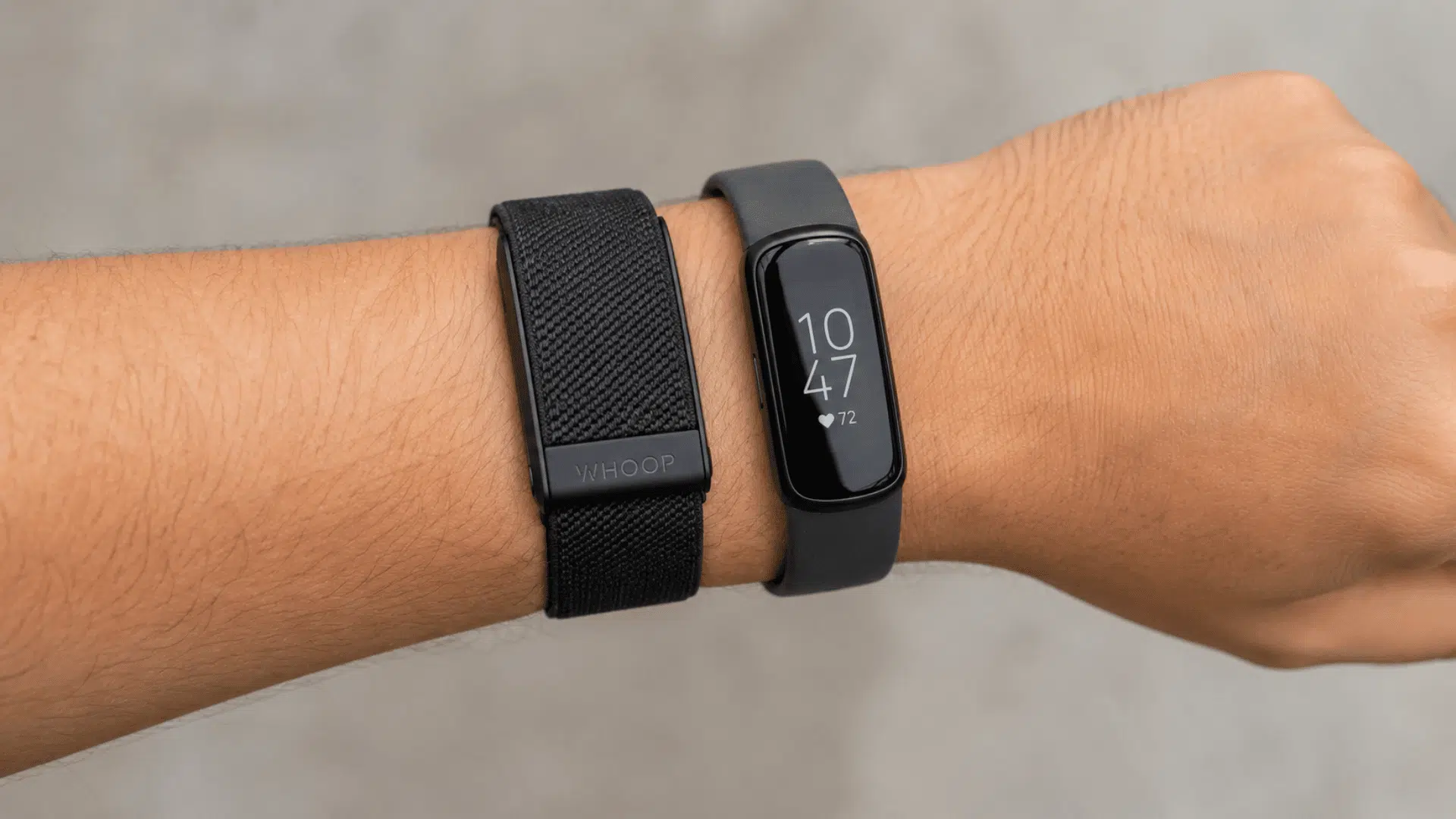 wrist wearing WHOOP and Fitbit fitness trackers side by side